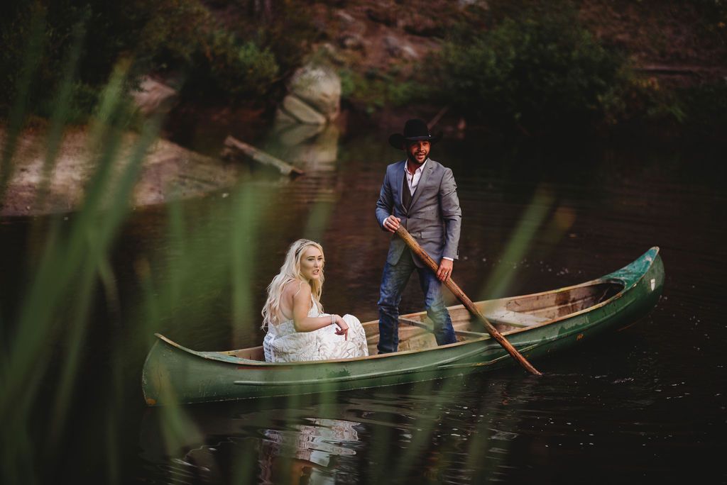 A romantic canoe ride on a serene lake with lush greenery framing the scene.