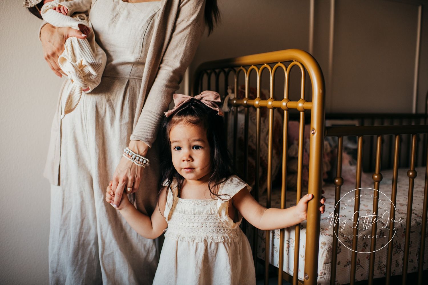 A nursery scene with a vintage gold metal crib and soft neutral decor.