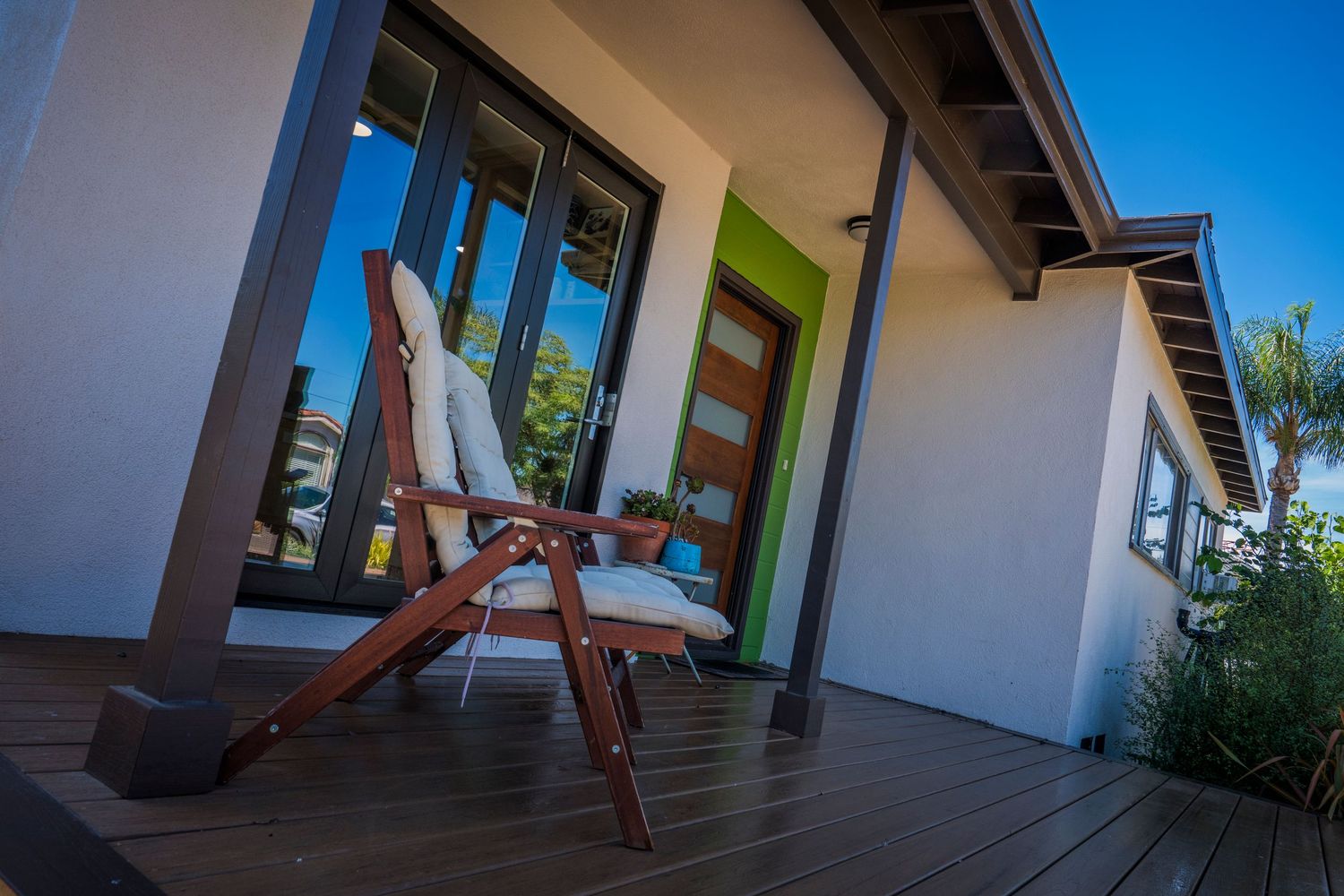 White modern home exterior with covered porch and contemporary architectural details.