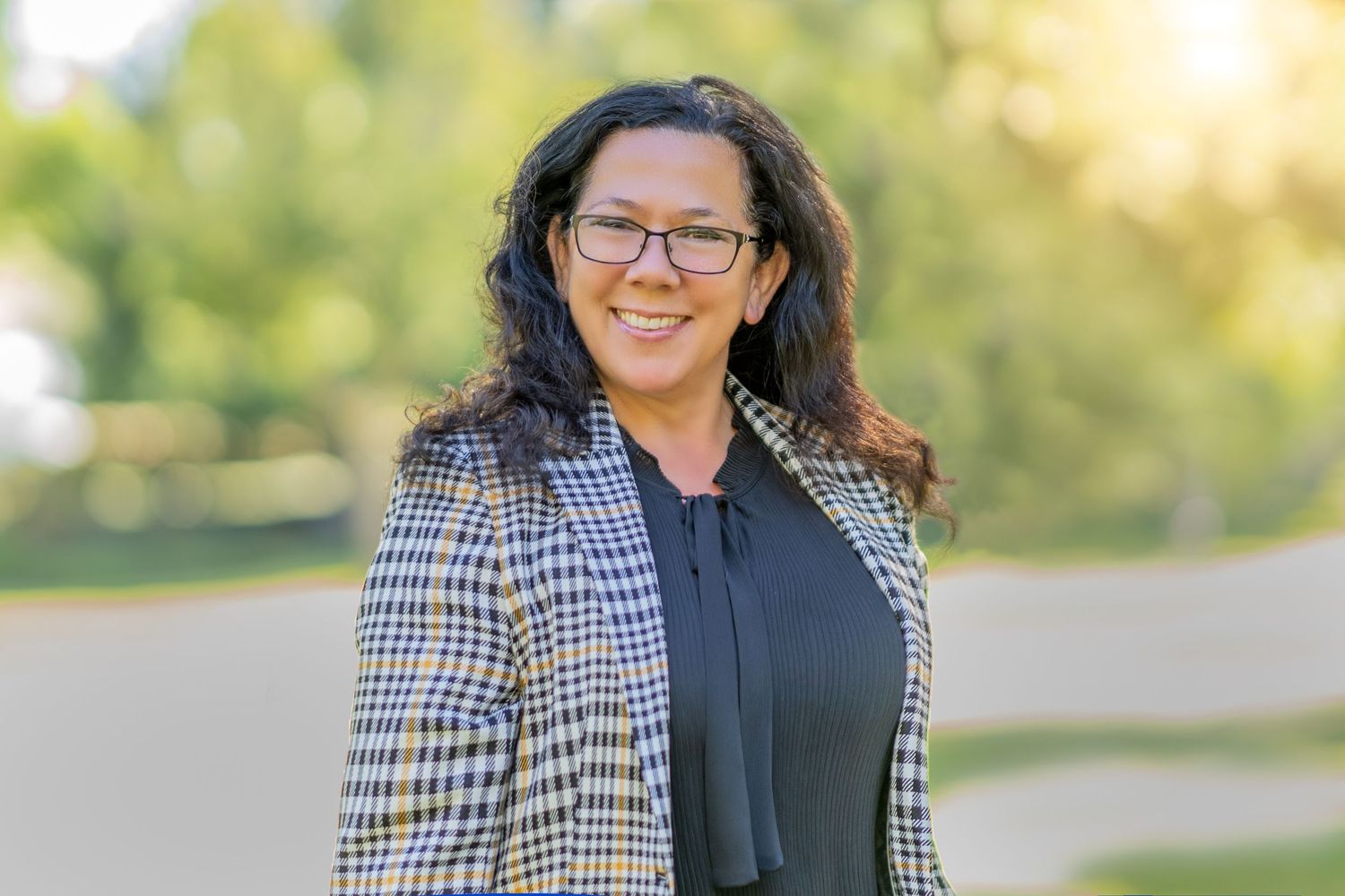 Professional outdoor portrait in business attire with plaid blazer.