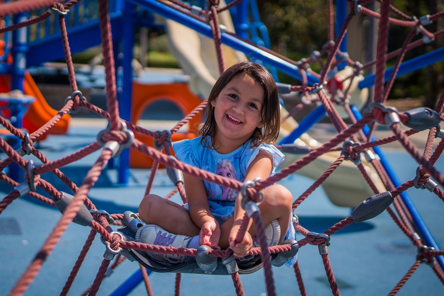 Detailed view of blue and red rope climbing equipment at a playground.