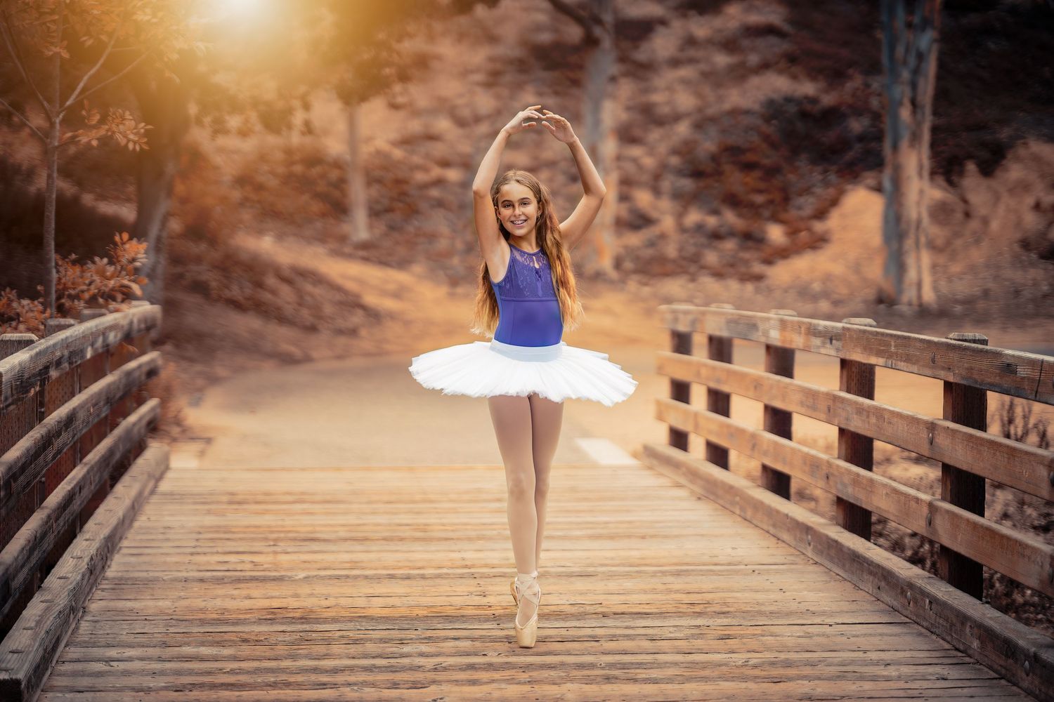 Dancing along a wooden boardwalk with dramatic sunlight filtering through trees.