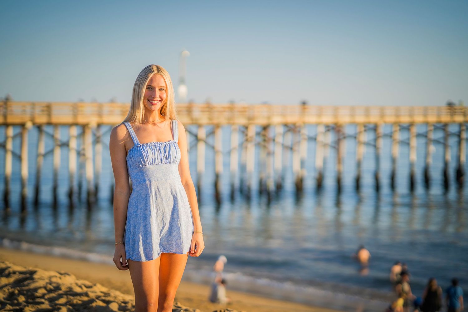 Light blue sundress captured at a beach pier during golden hour.