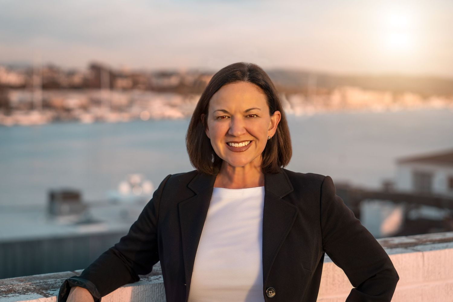 Professional portrait by the waterfront with soft evening lighting.