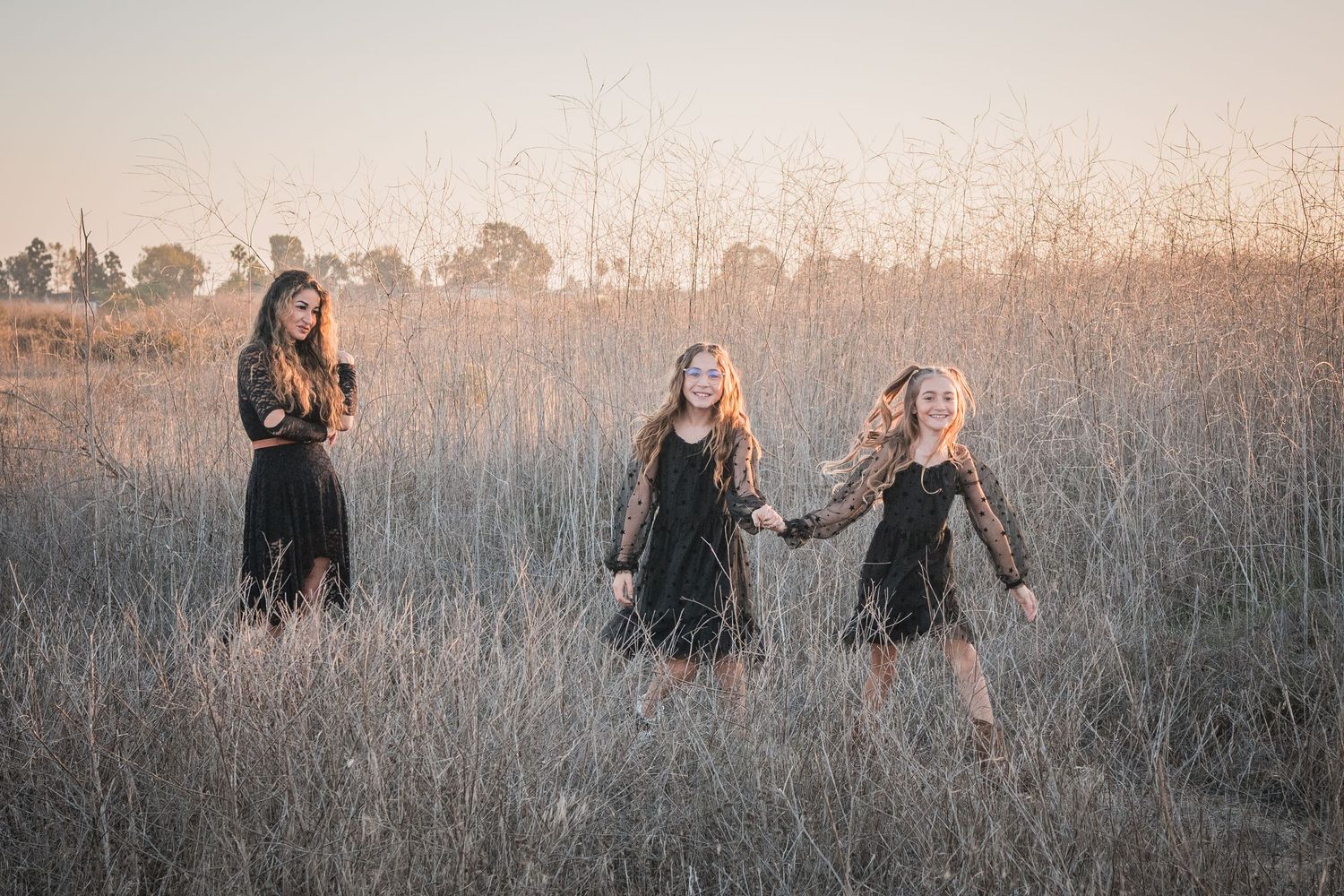 A series of dreamy, muted photographs showing people walking through a misty field at sunset.