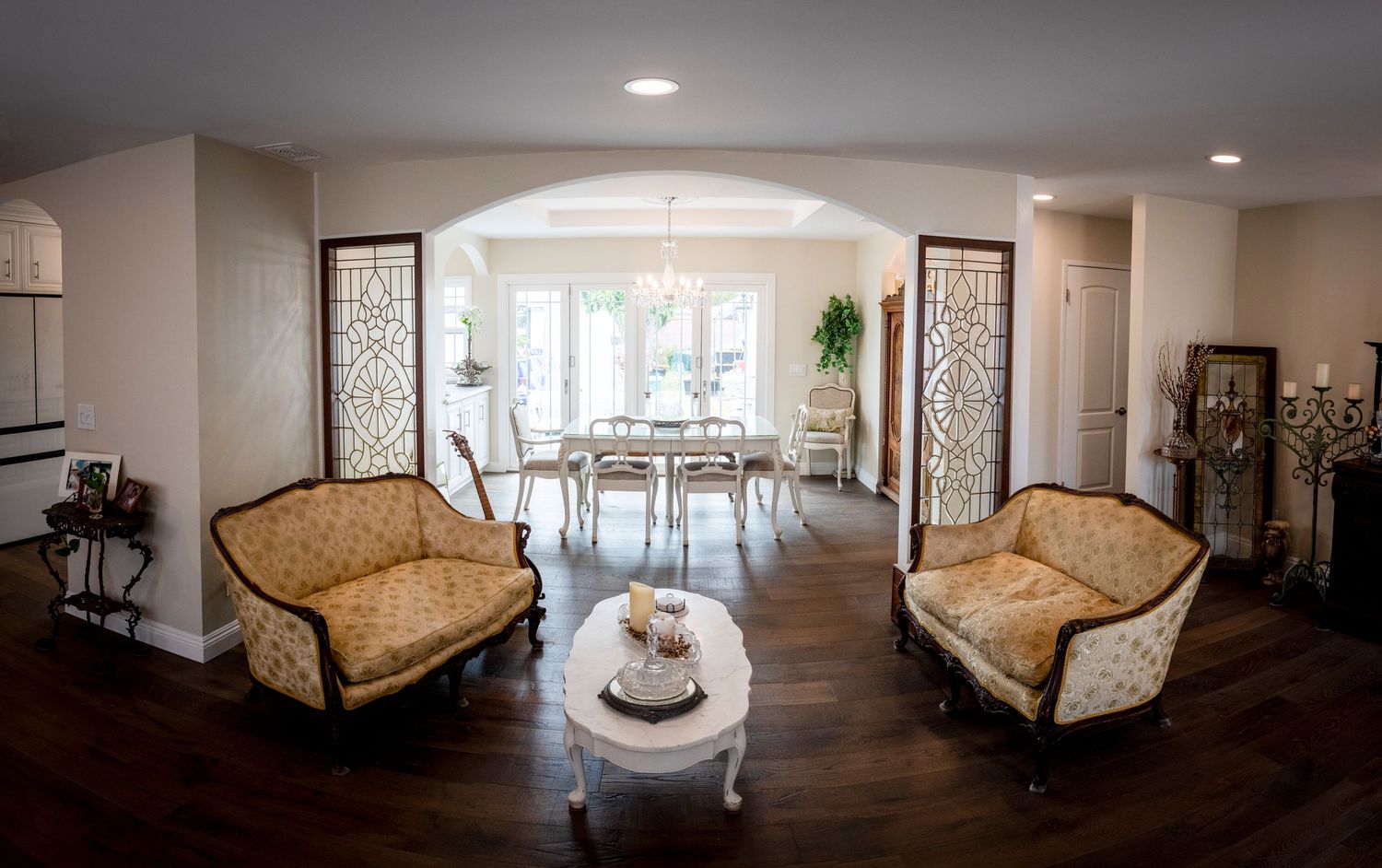 Elegant living room interior with curved walls, recessed lighting, and classic furniture pieces.