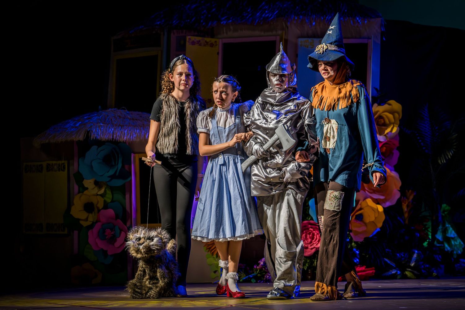 Theater performance on stage with dramatic blue lighting and period costumes.