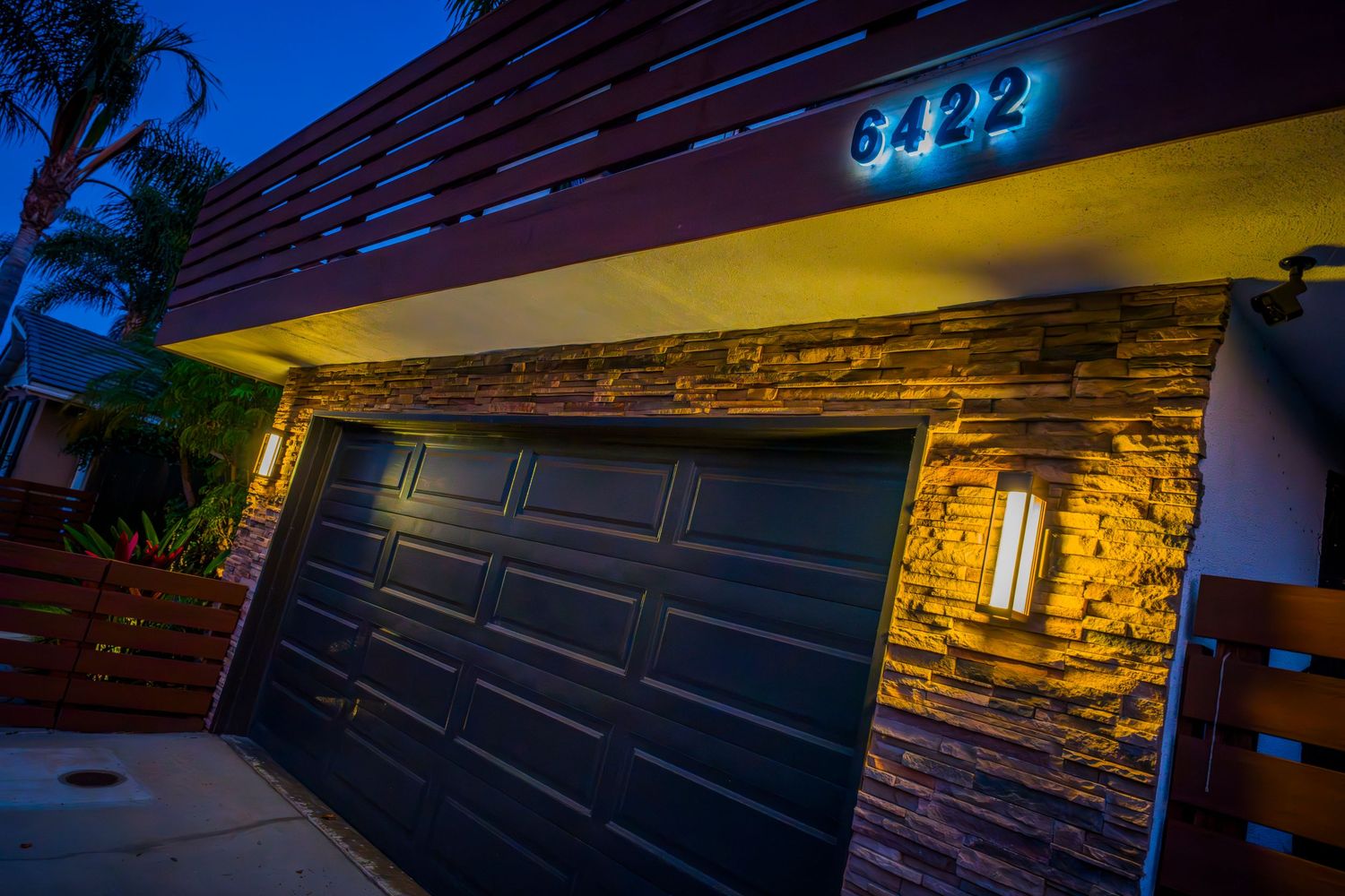 Dramatic architectural detail of modern home exterior with accent lighting at dusk.