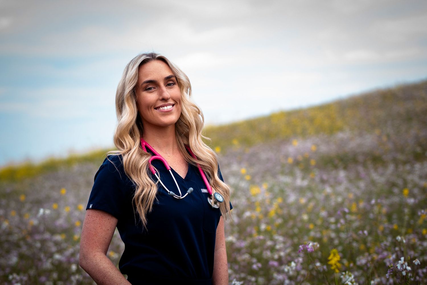 Natural outdoor portraits taken in a wildflower field under cloudy skies.