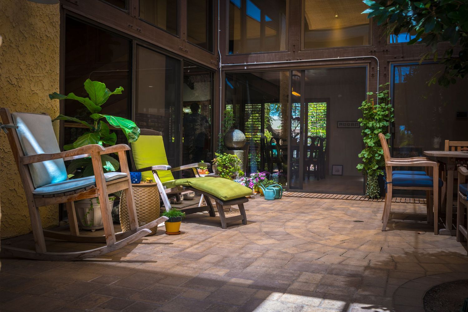 Spacious covered patio area with tile flooring and outdoor furniture overlooking a garden.