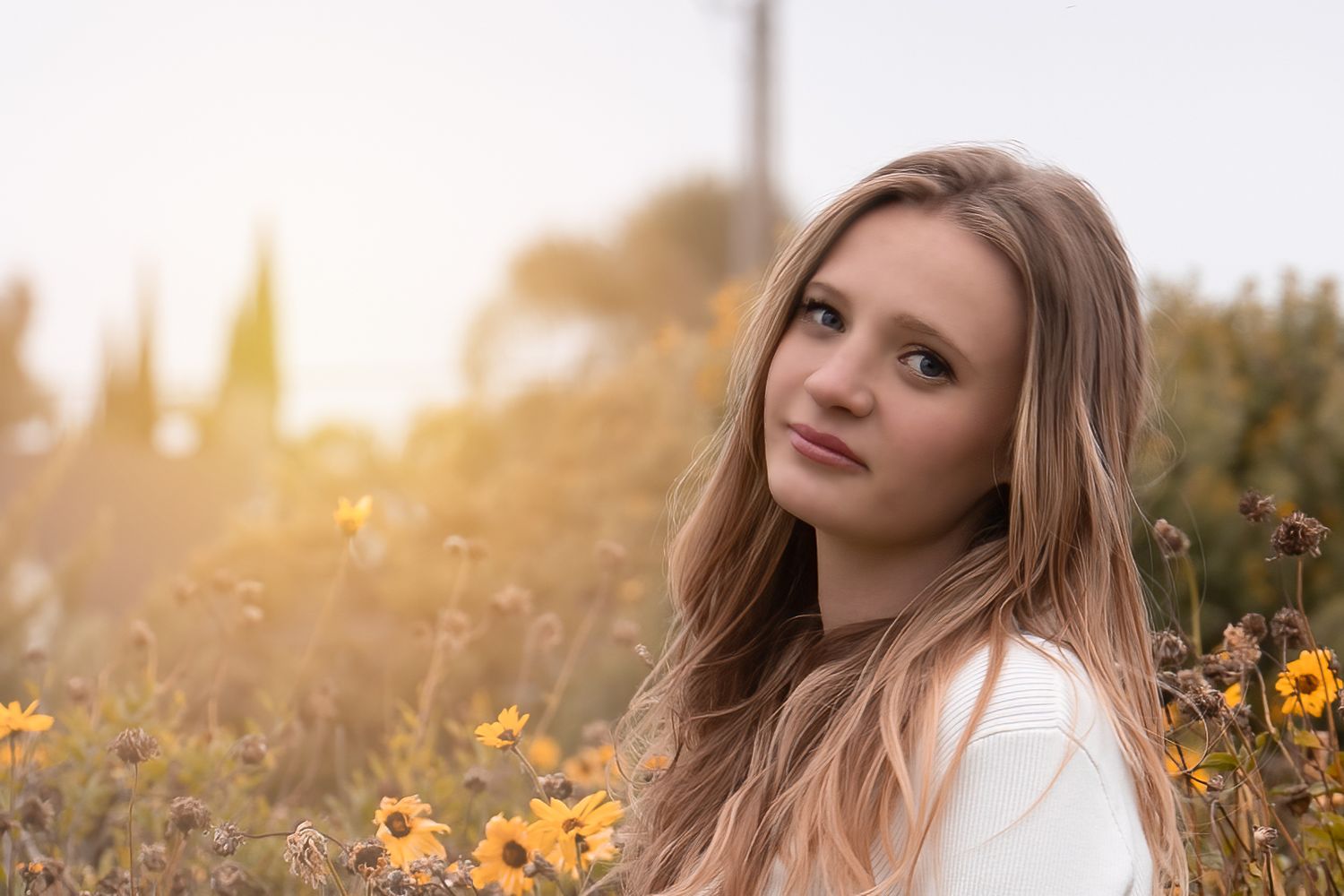 Outdoor portrait in field of yellow flowers during golden hour.