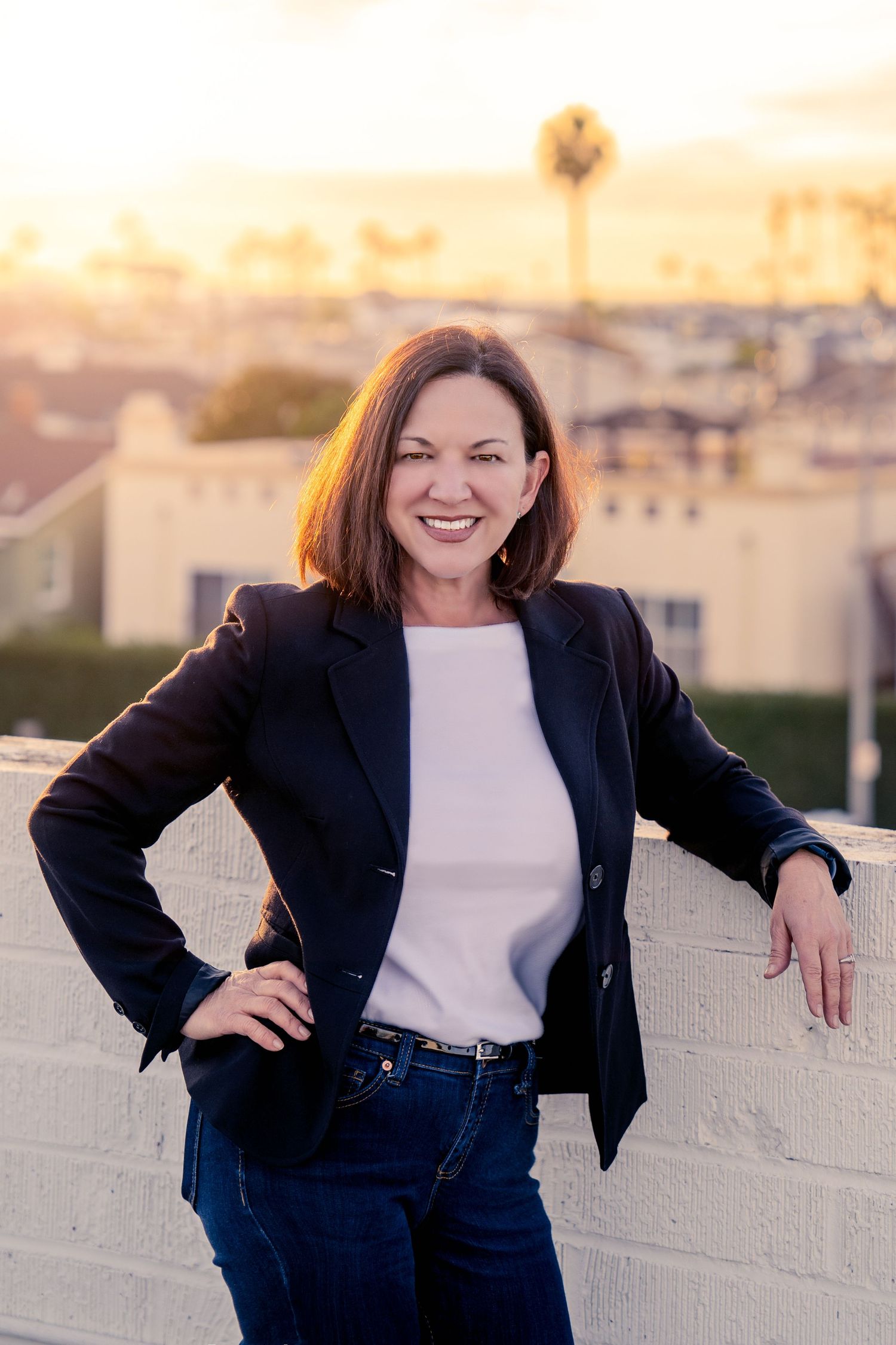 Professional headshot against white wall during sunset showing confident business poses.
