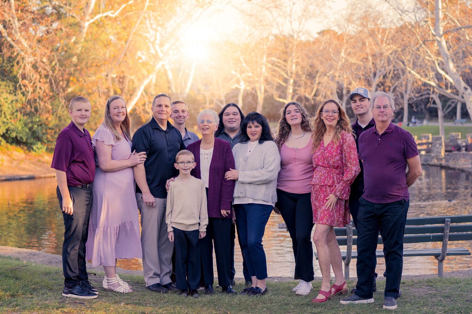 Large extended family group portrait in a park setting during golden hour.