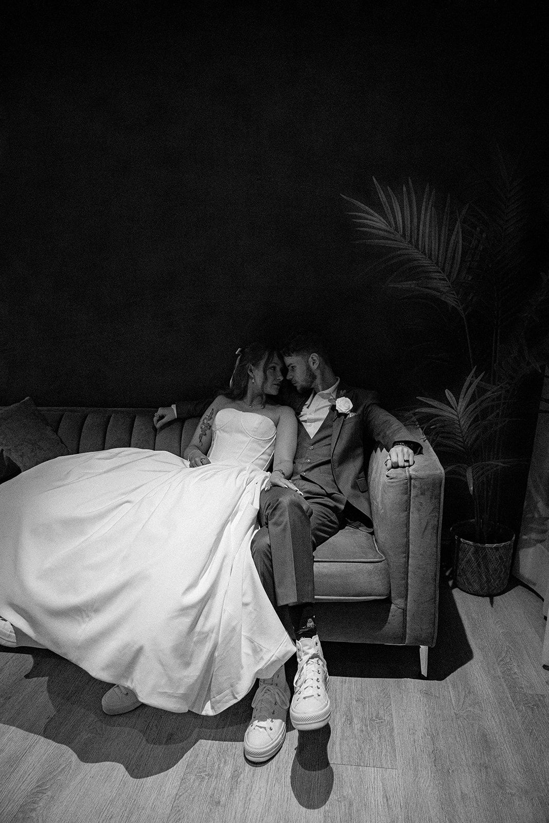 Black and white portrait of a bride and groom sharing an intimate moment, gazing at each other with soft, emotional expressions in a quiet,