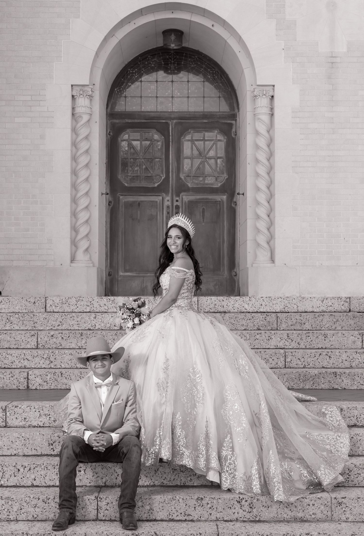 A black and white photo series showing a couple in wedding attire posing on stone steps of a historic building.