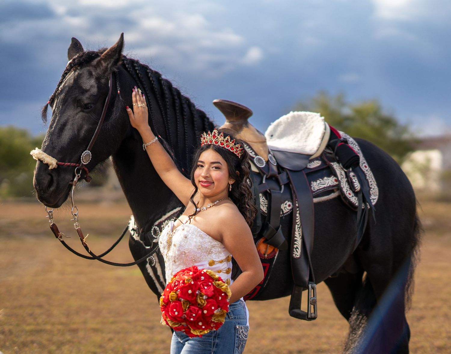 A black horse and person in western attire share a tender moment in an outdoor setting.