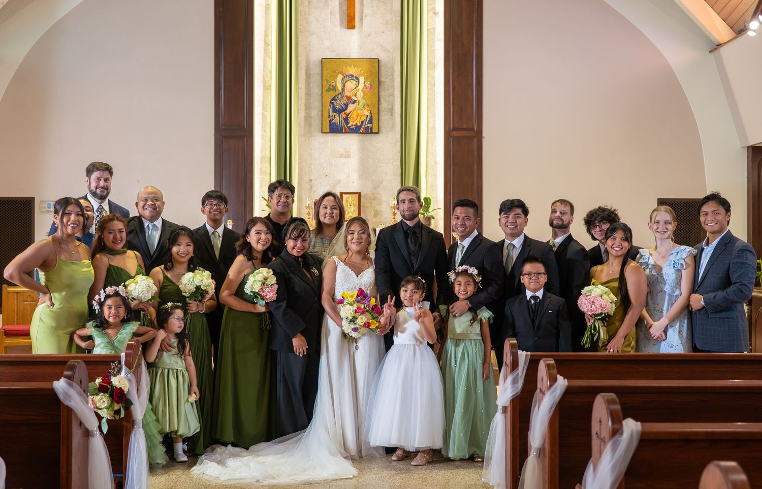 A church wedding ceremony with guests seated in pews and floral decorations.
