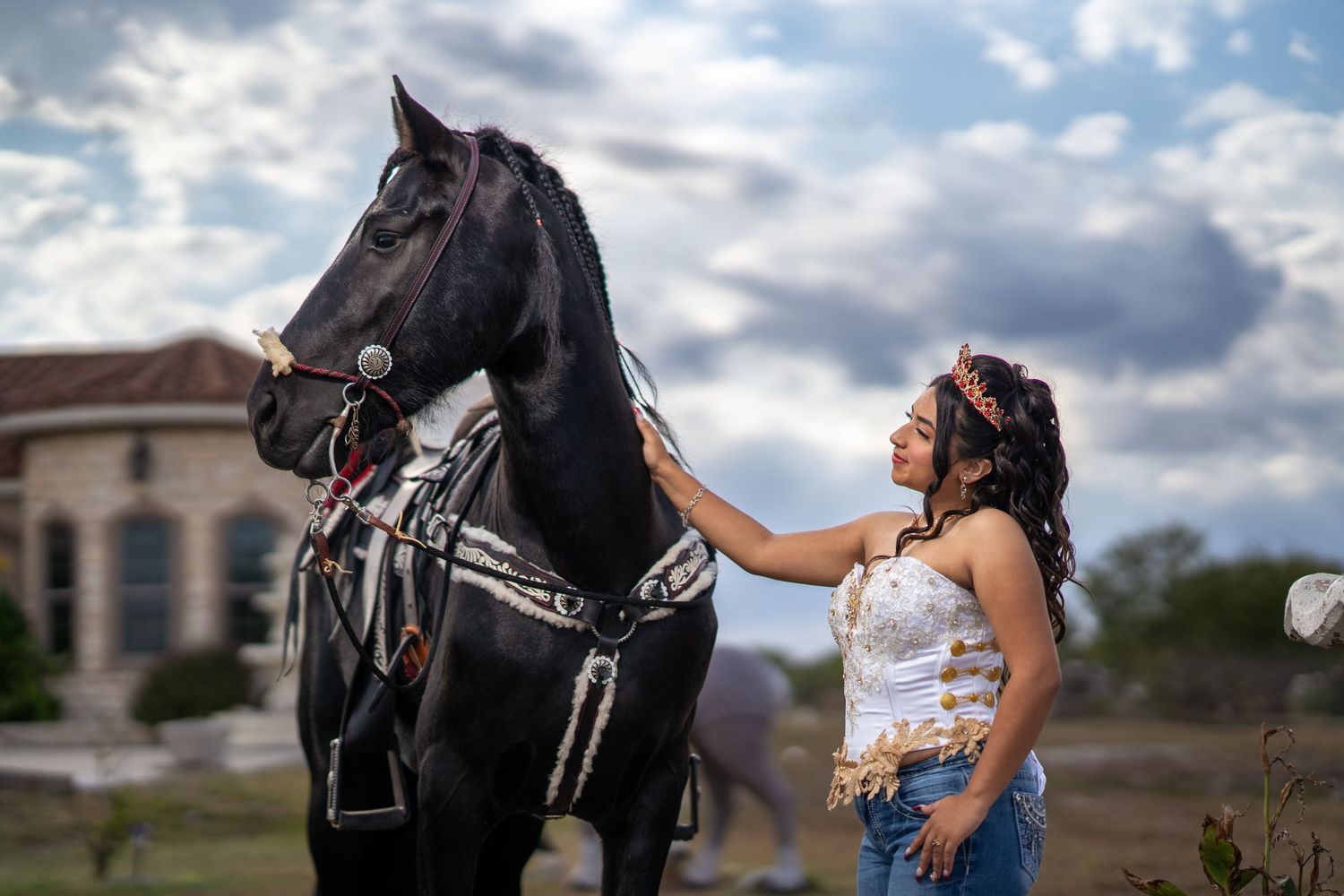A couple poses outdoors with a beautiful cloudy sky backdrop during a romantic photoshoot.
