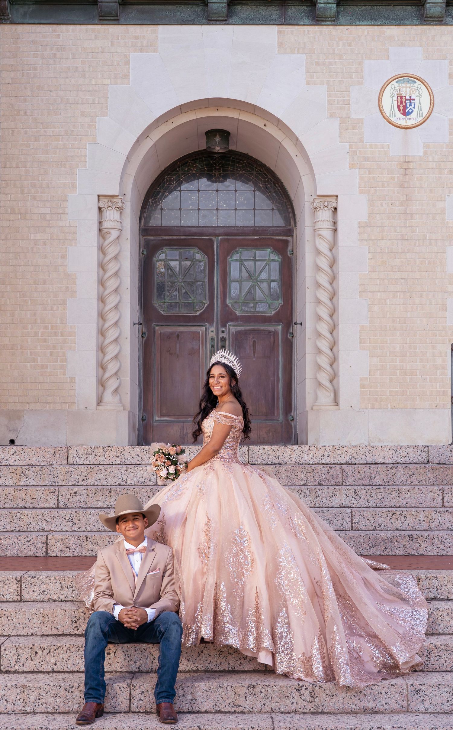 Elegant quinceañera portraits showcasing a flowing pink dress and western style against an ornate church backdrop.