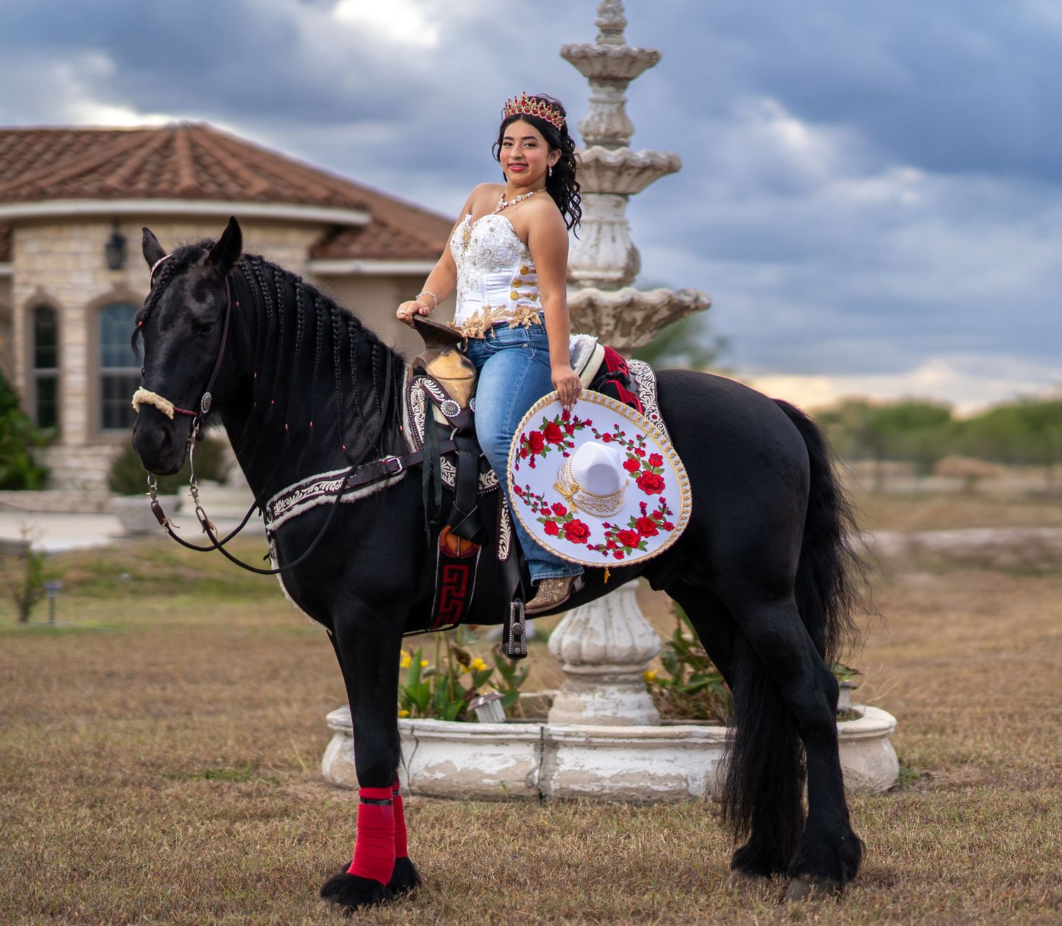 A black horse stands near an ornate stone fountain while someone poses with a decorative fan.