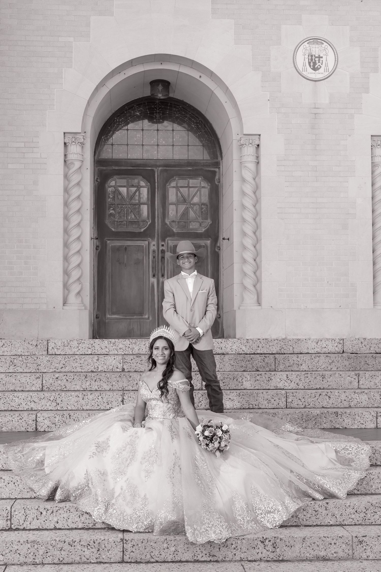 A series of black and white wedding photos showing a couple posing on stone steps outside an elegant building entrance.