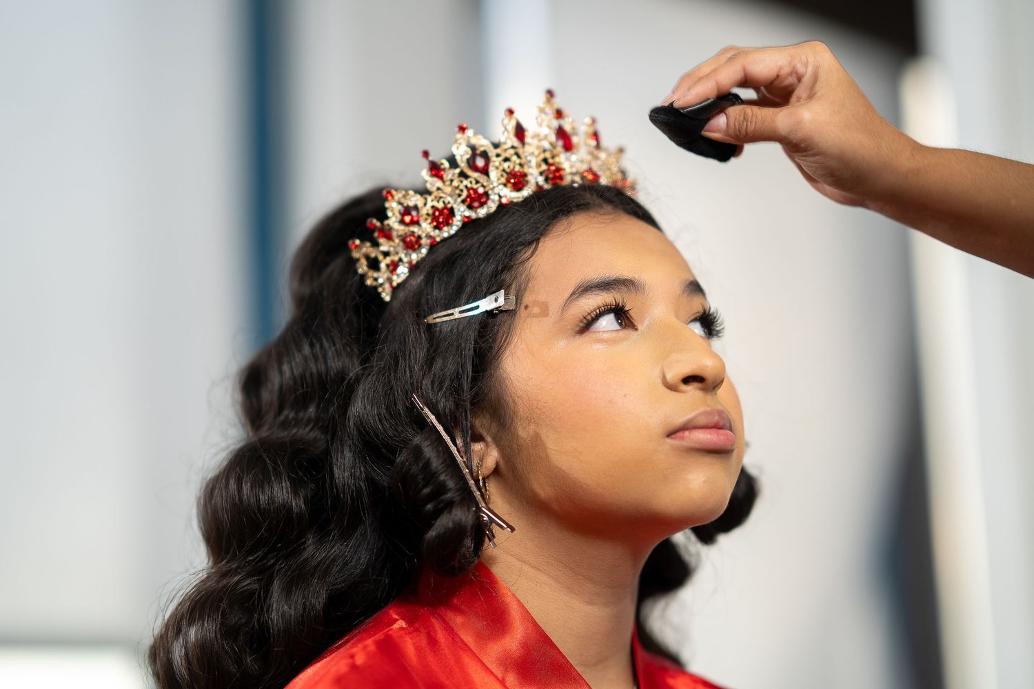 A hairstylist applies finishing touches to a formal hairstyle during a professional styling session.