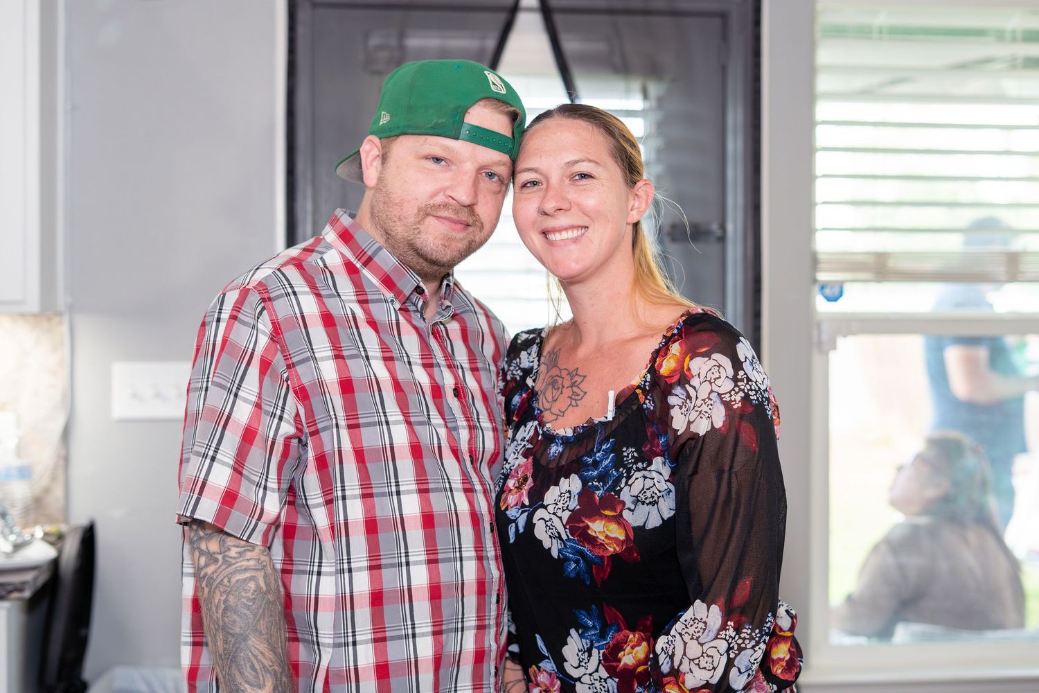 Smiling couple posing together indoors at a casual celebration event.