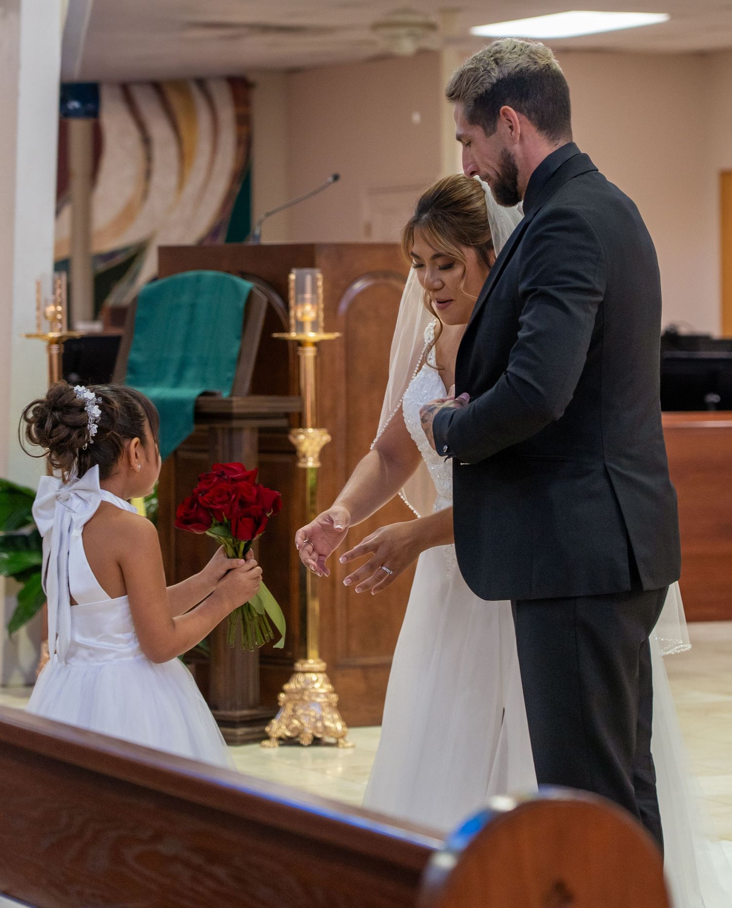 Couple in formal wedding attire sharing a romantic dance moment in a church sanctuary.