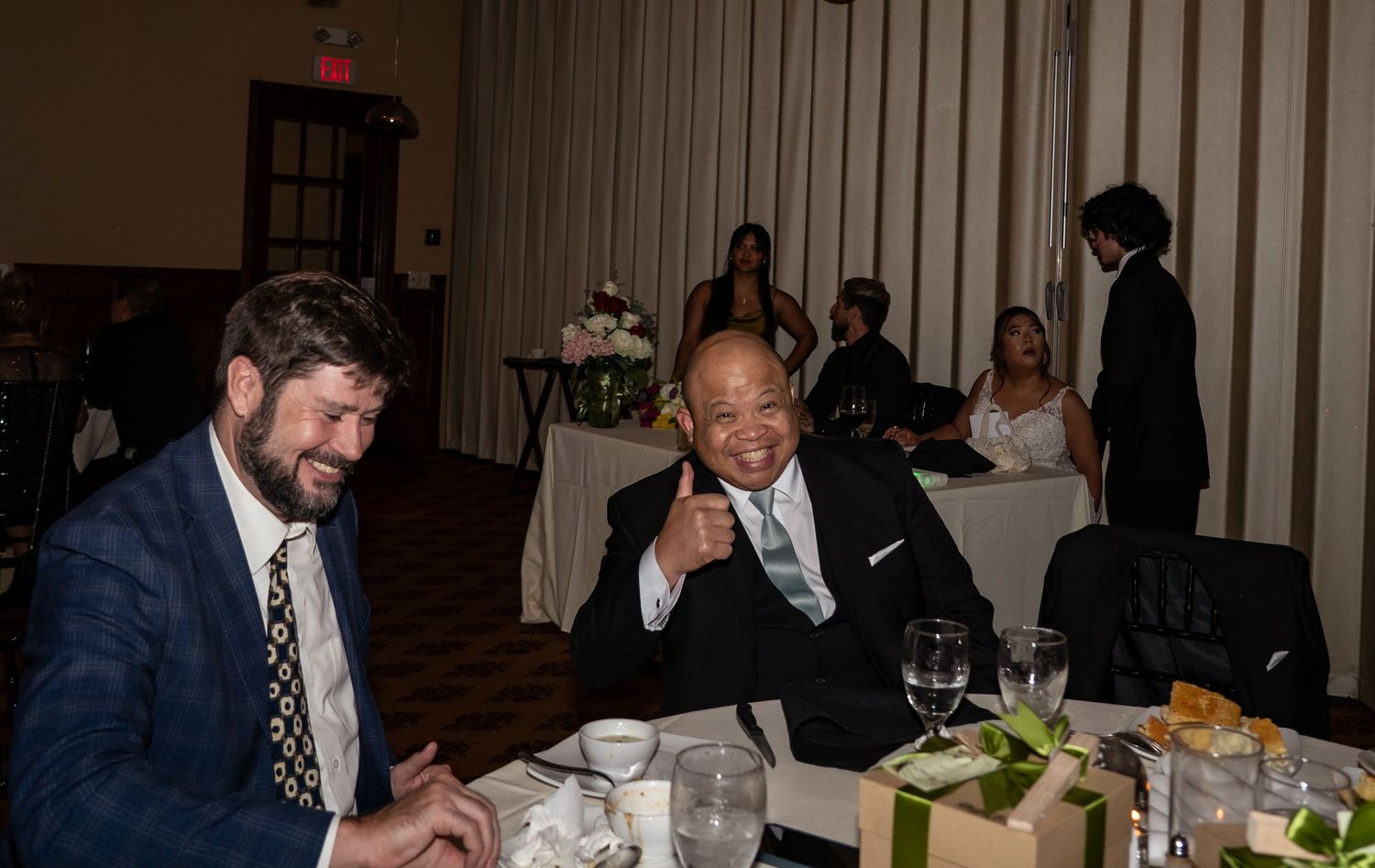 Wedding reception guests seated at tables enjoying dinner and conversation.