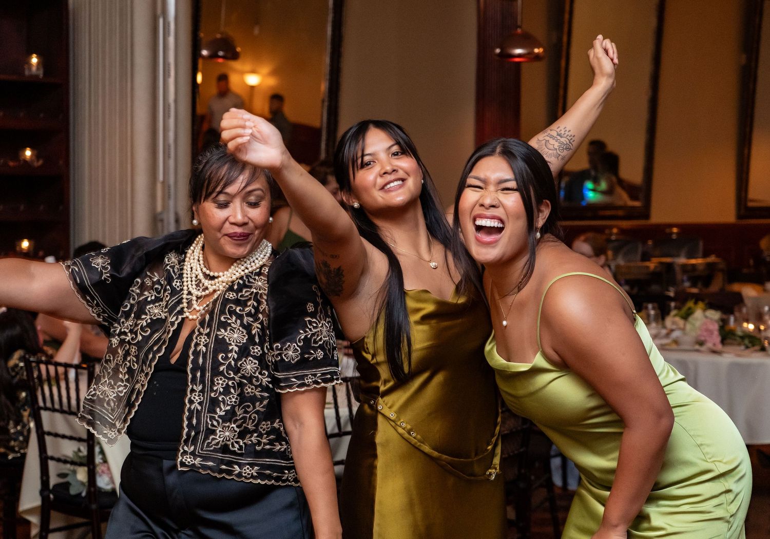 Wedding party guests dancing and celebrating together on the dance floor at a reception.
