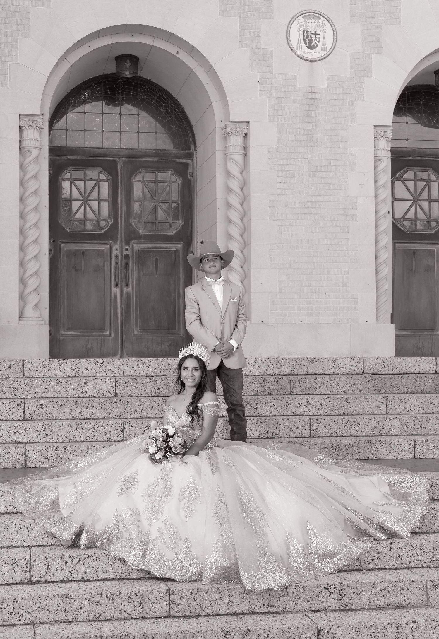 A sequence of black and white photos showing a bride in a flowing white gown posing on stone steps of a building.