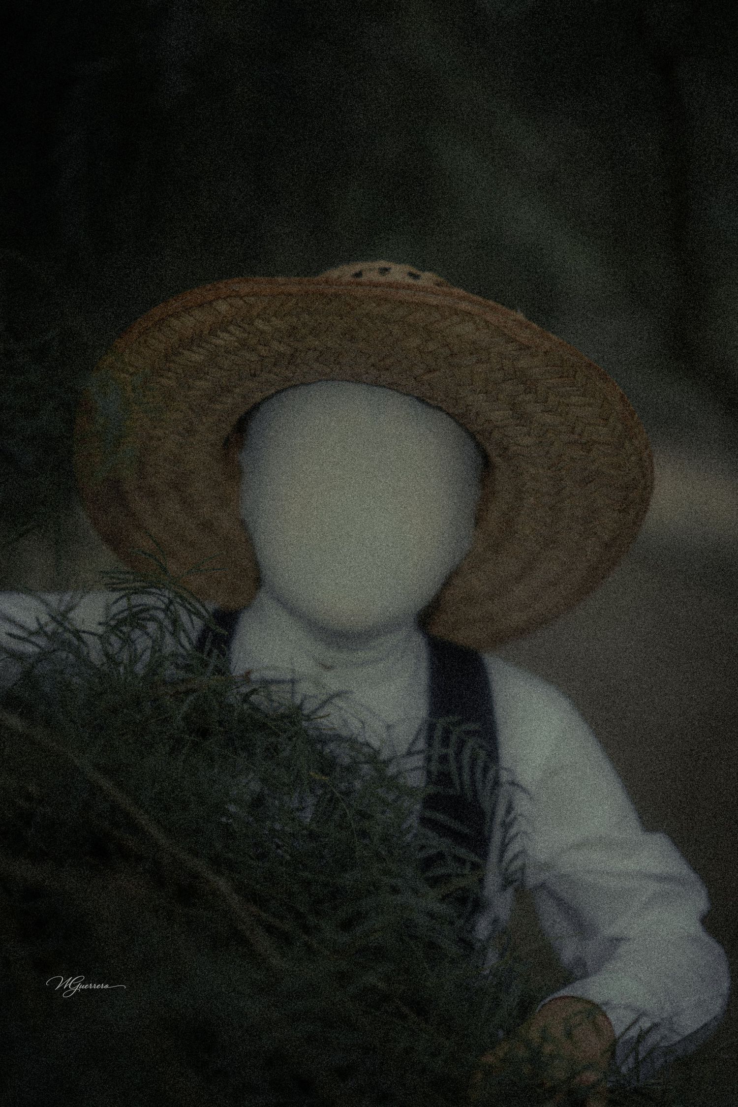 Faceless mannequin in suspenders and straw hat holding greenery in a dark atmospheric artistic photo.