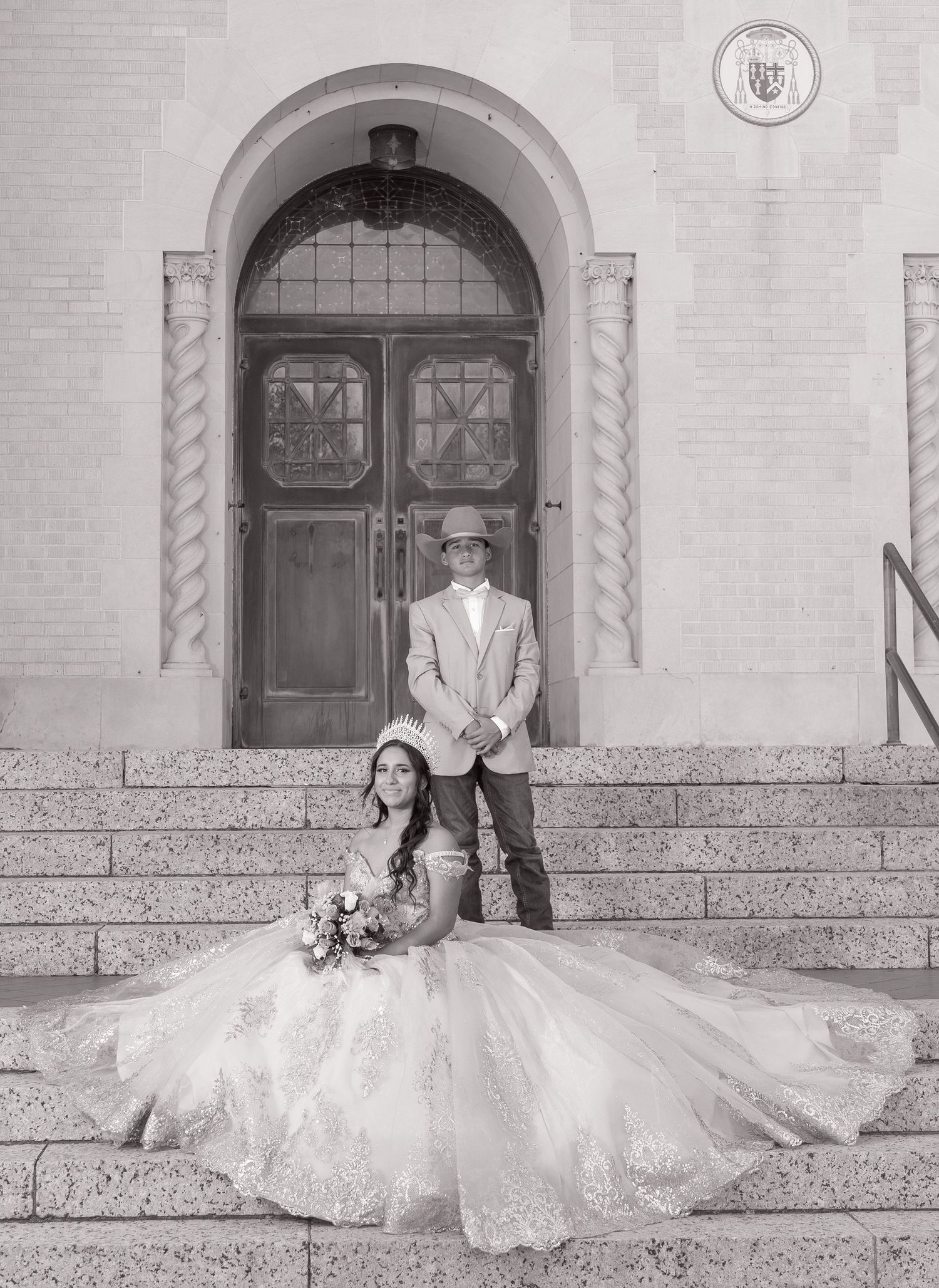 Black and white wedding photos showing a bride in a flowing white dress seated on church steps with her dog.
