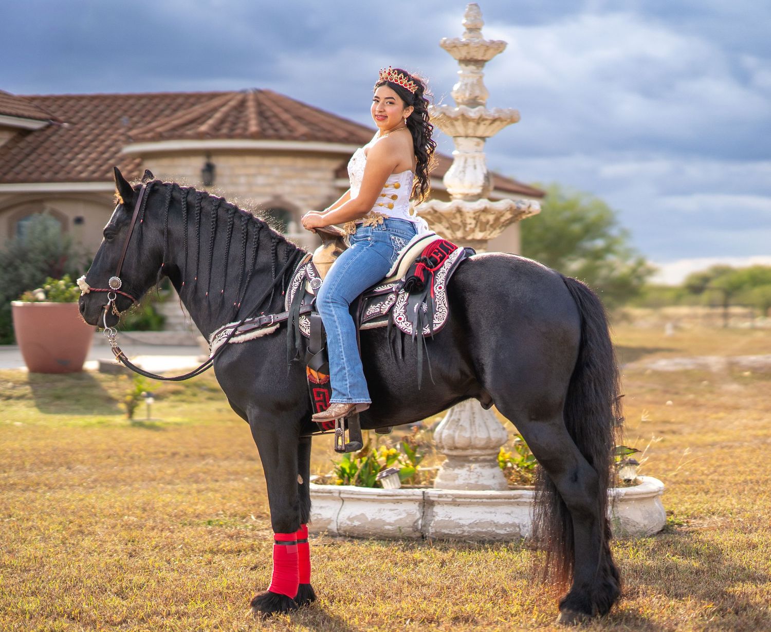 A decorative fountain serves as backdrop for a photoshoot with a horse in an outdoor setting.