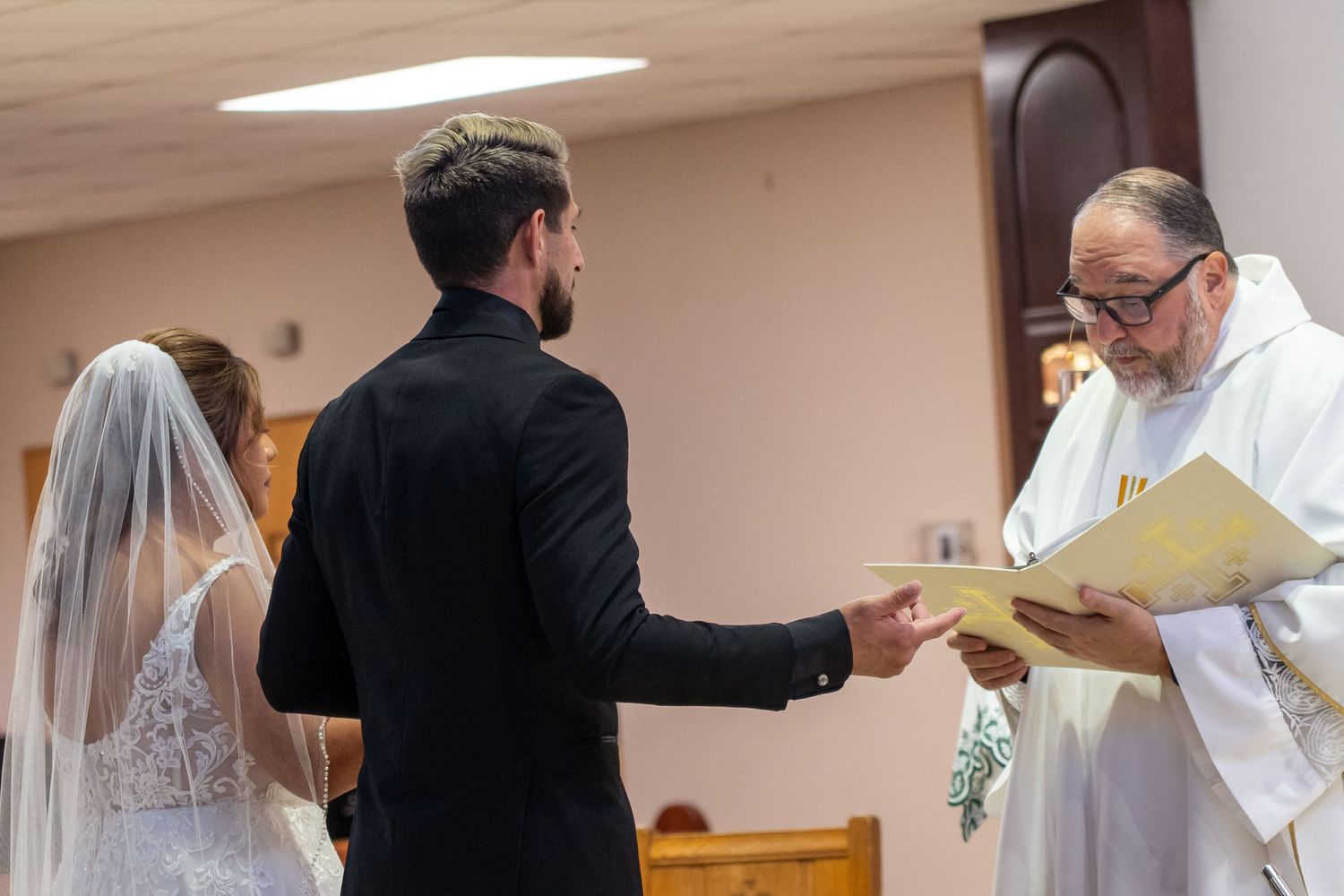 People in white robes stand in a church during a religious ceremony or service.