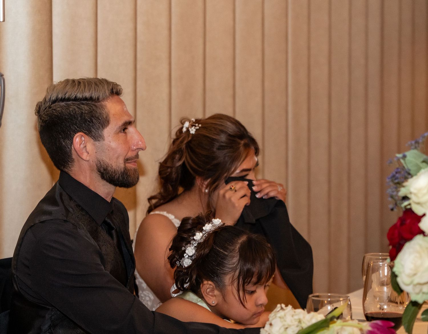 Wedding reception celebration with guests seated at decorated tables in a banquet hall.