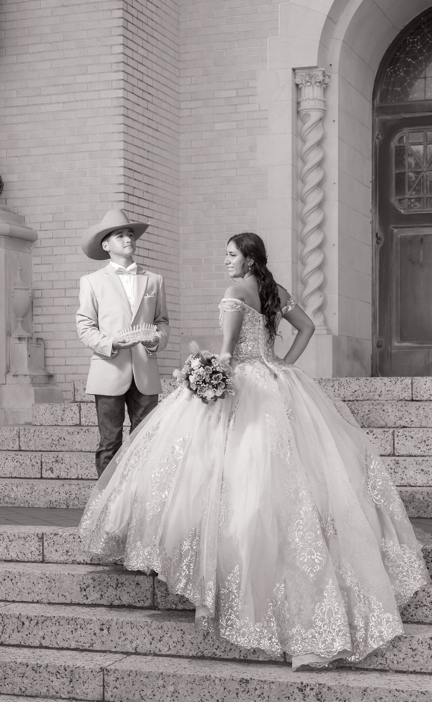 Black and white photos showing a bride in a voluminous lace gown posing on architectural stone steps.