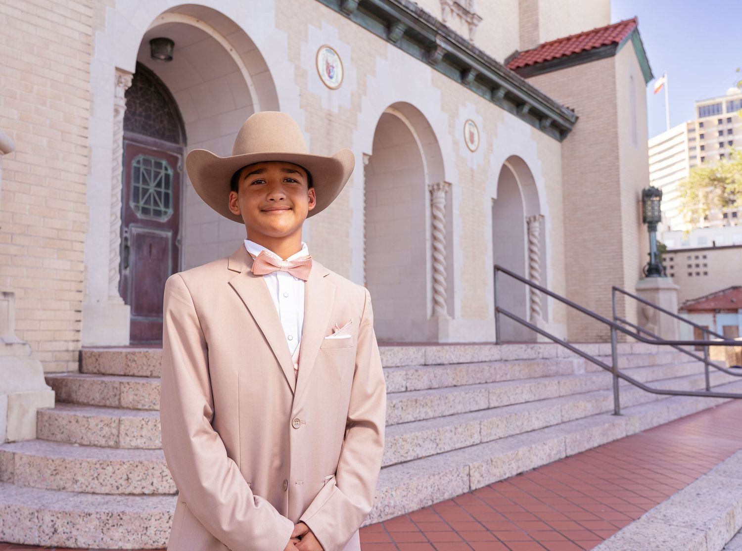 Formal western-style portraits taken outside a historic stone building with decorative architectural details.