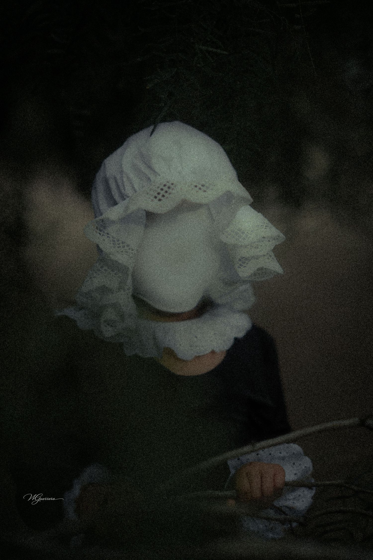 Eerie faceless child figure wearing a white lace bonnet and dark dress holds a flower in a dark, moody setting.