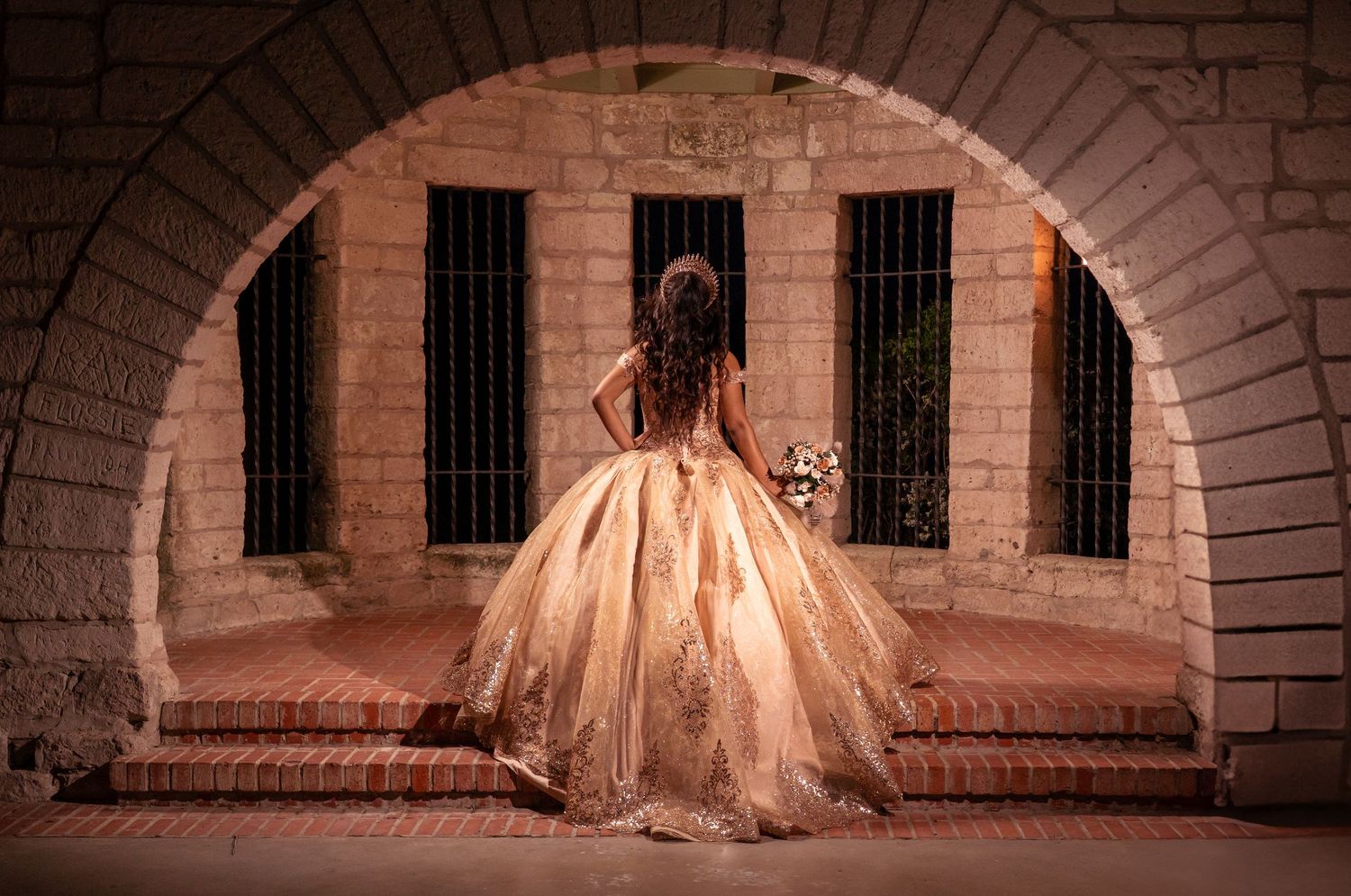 A sweeping pink ballgown captured in a sequence of frames under historic stone arches.