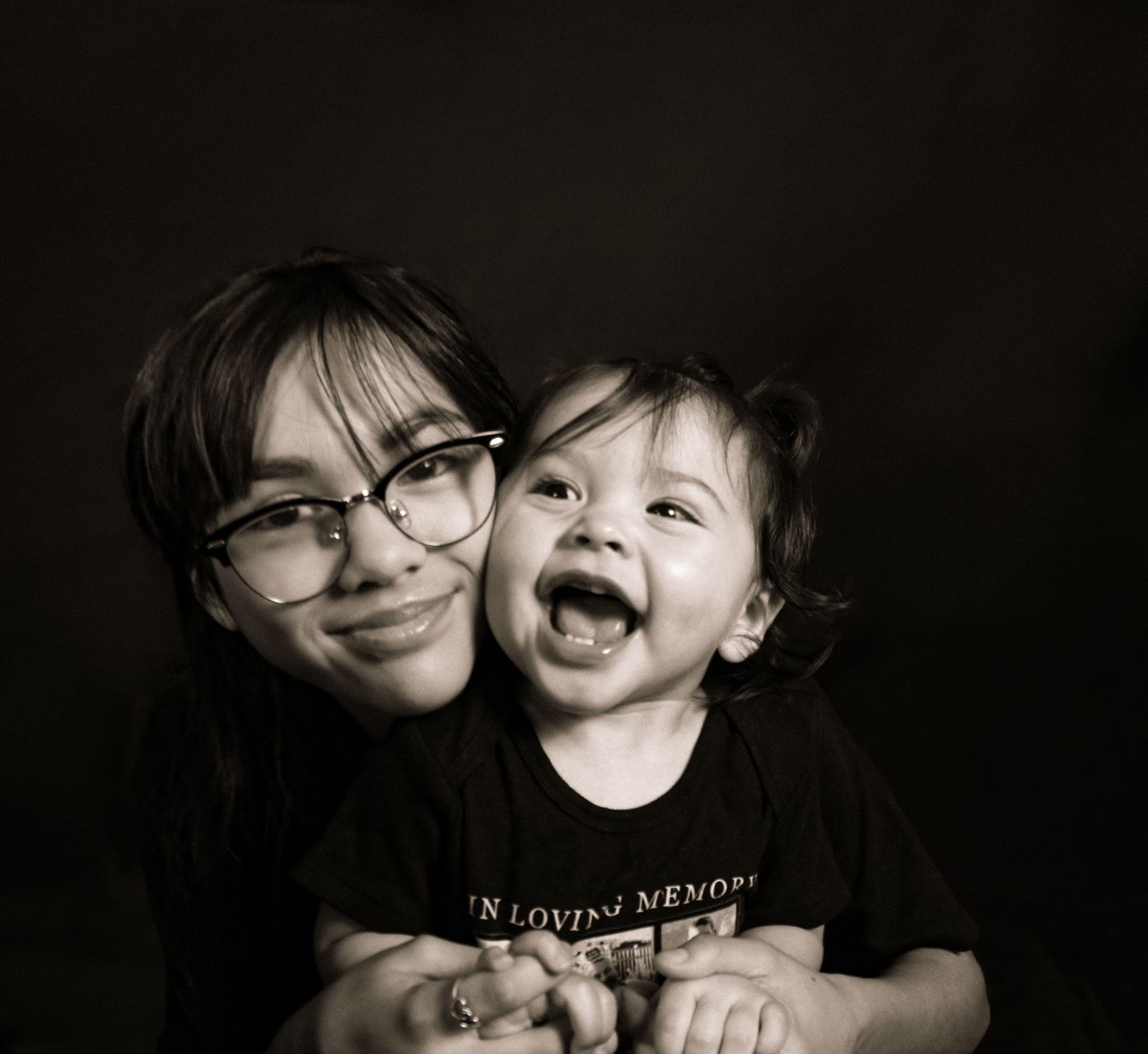 A black and white portrait of a parent and child sharing a joyful moment together.