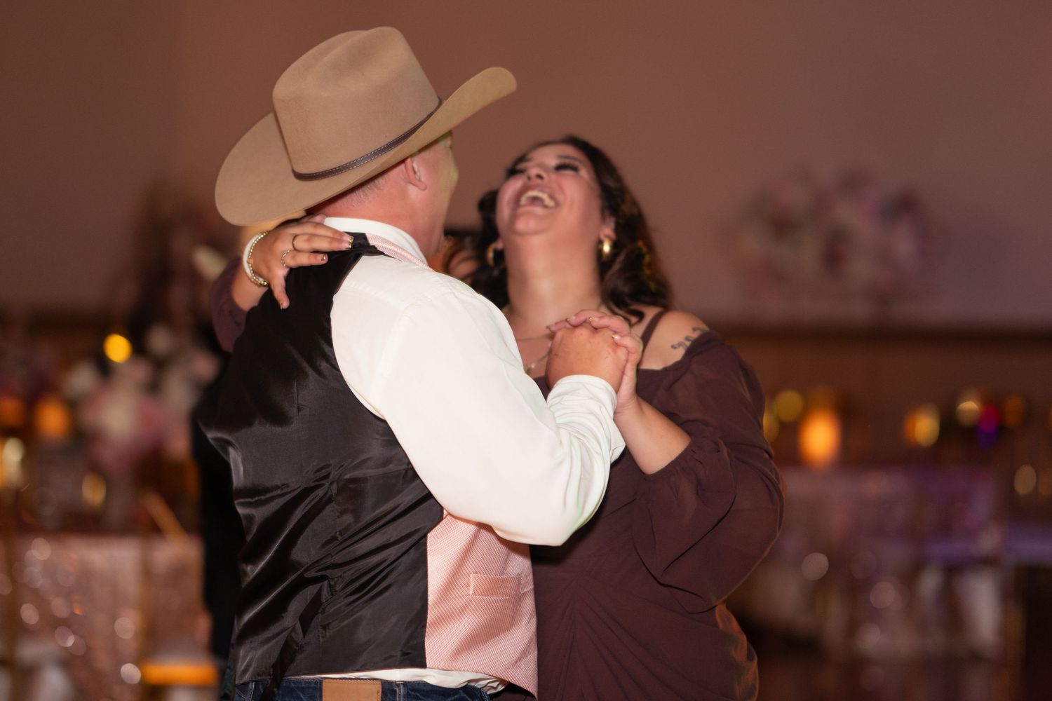 Couple shares an intimate dance at a quinceañera celebration with warm ambient lighting.