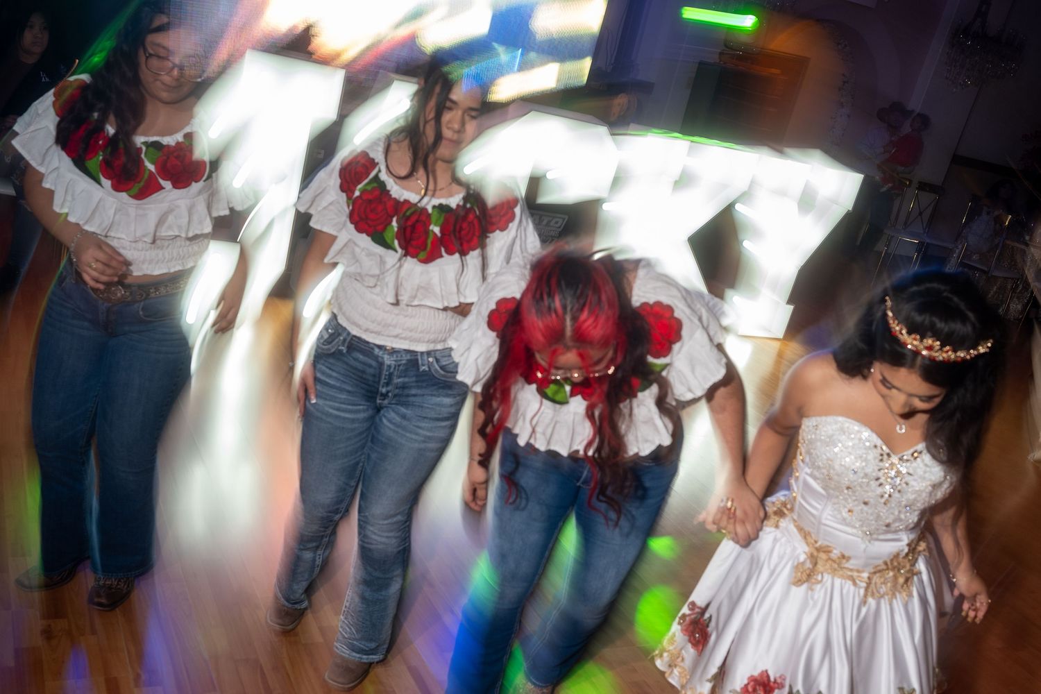 People dancing and celebrating at a lively party with colorful lighting and festive atmosphere.