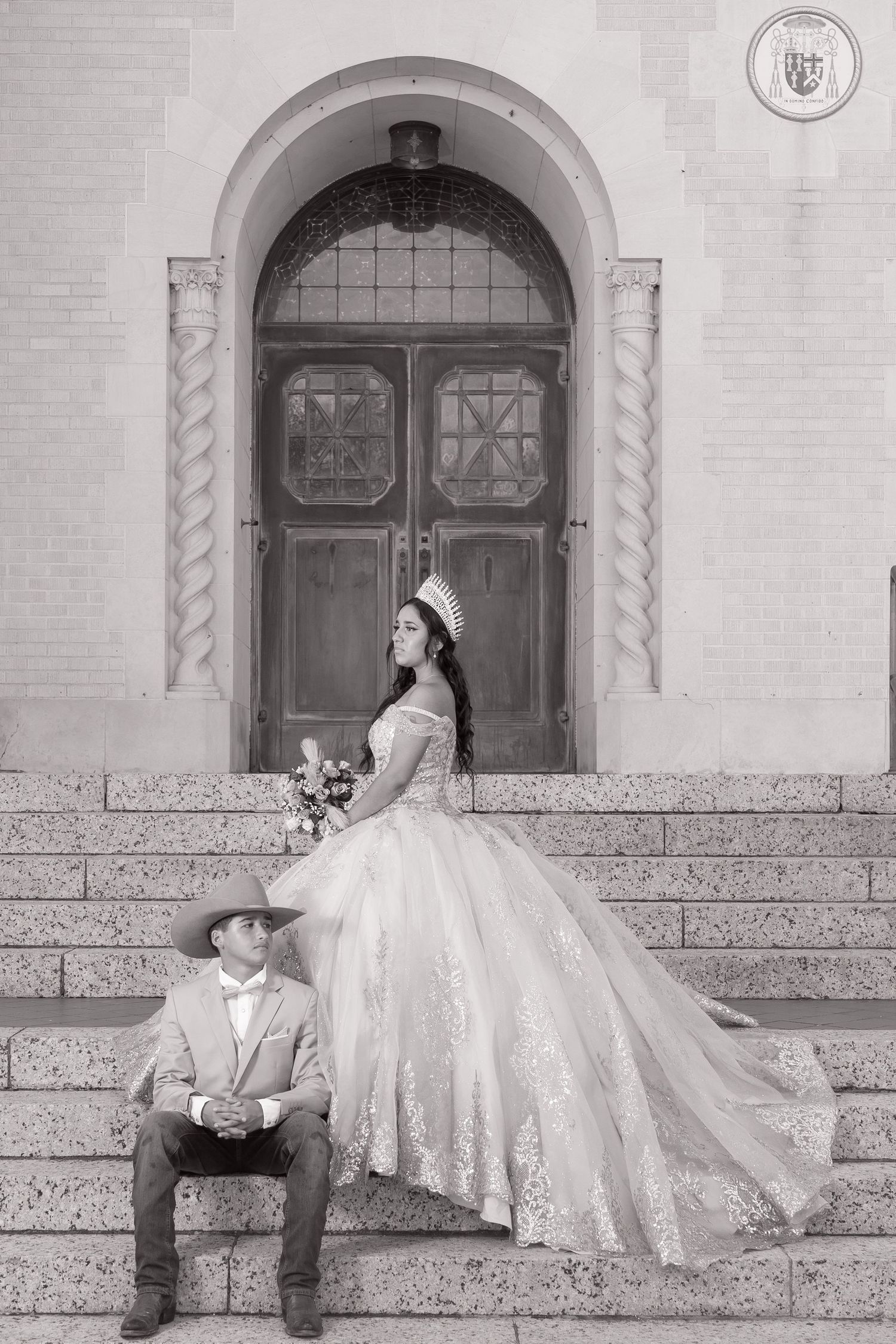Black and white wedding photos showing a couple in elegant attire posing on stone steps of a historic building.
