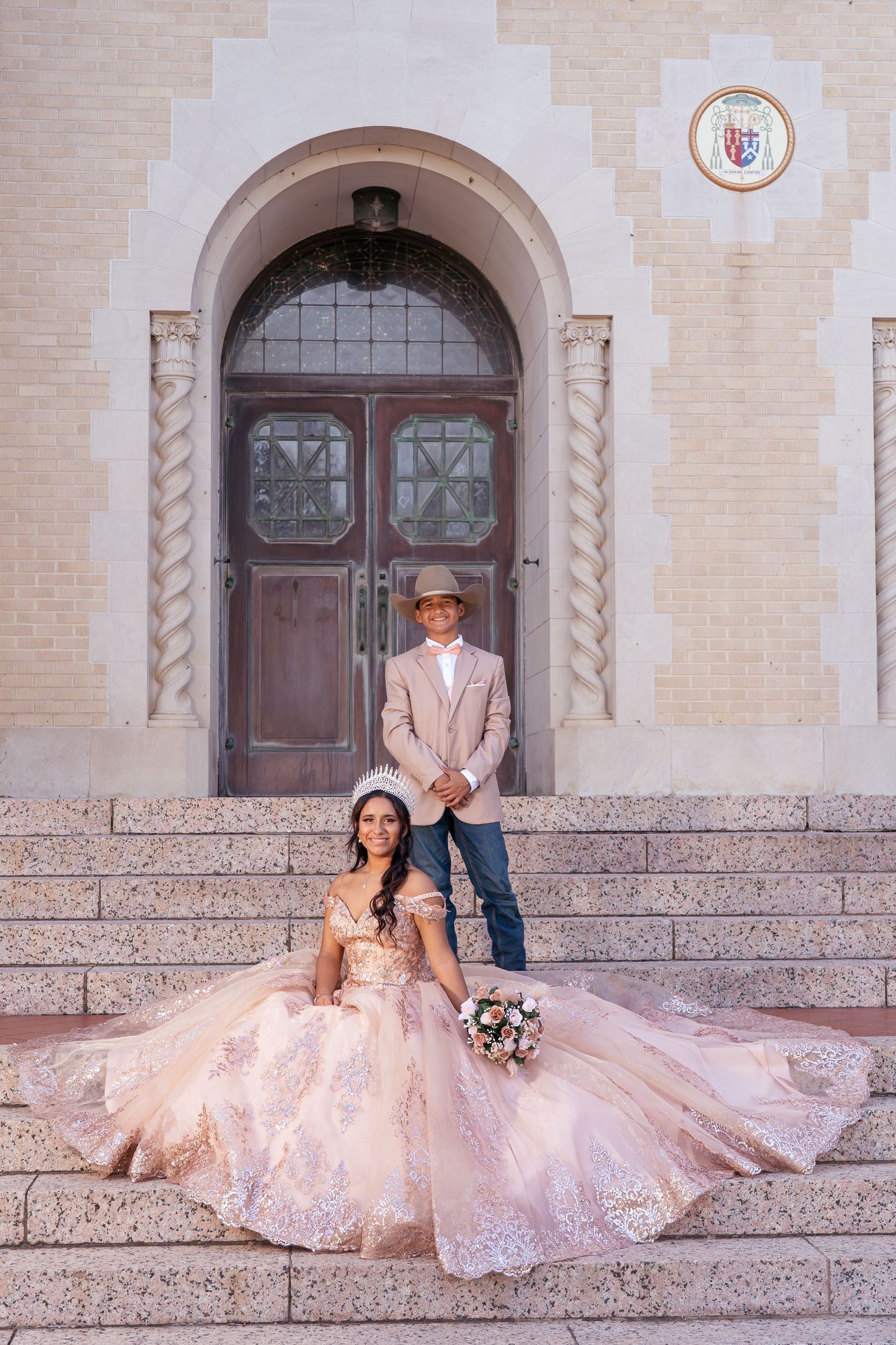 Romantic wedding portrait on grand stone staircase with ornate architectural details.