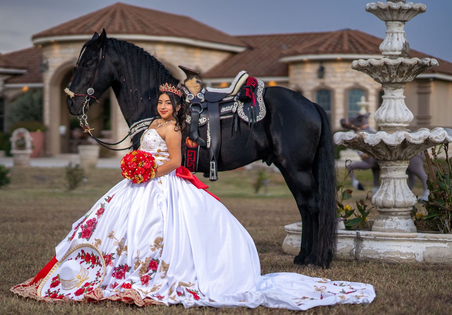 A flowing white and red dress creates a dramatic scene against an architectural backdrop with fountain.