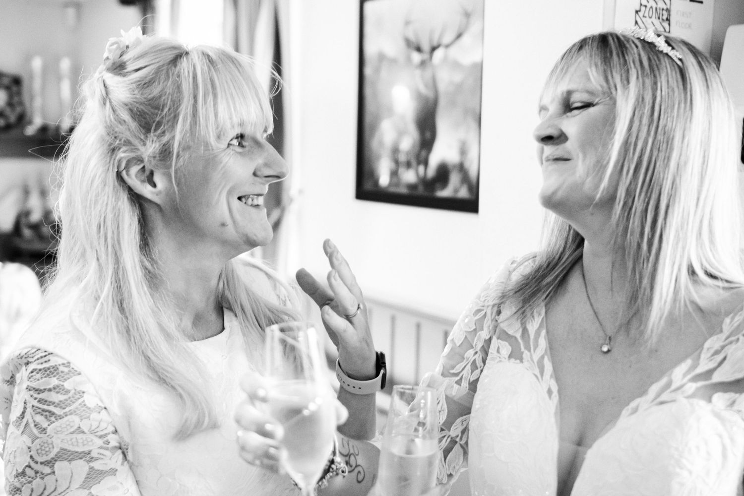 Five black and white photos showing candid laughing moments captured in a bright indoor setting.