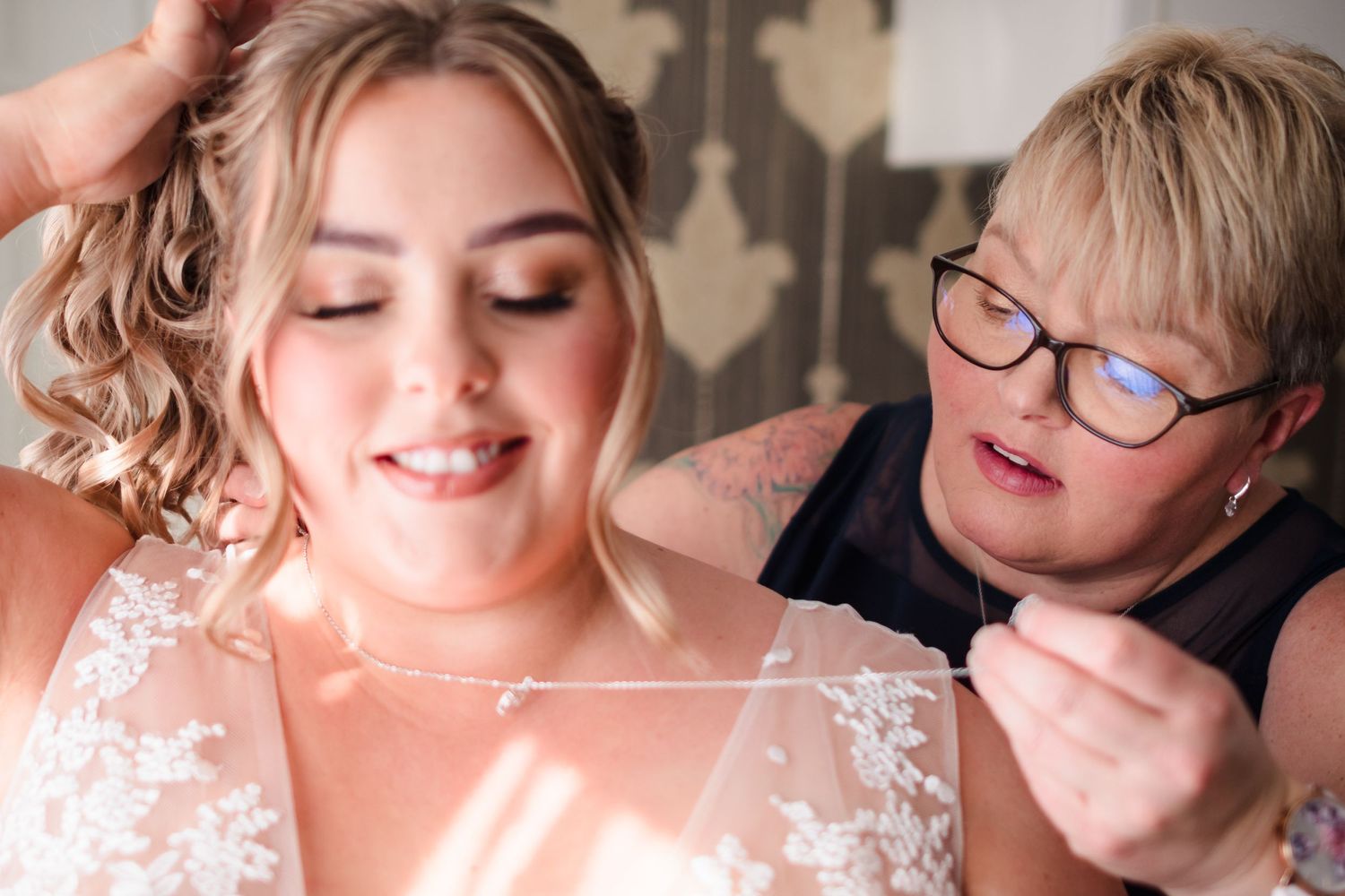 An intimate getting-ready moment shows final wedding day preparations with delicate lace details.