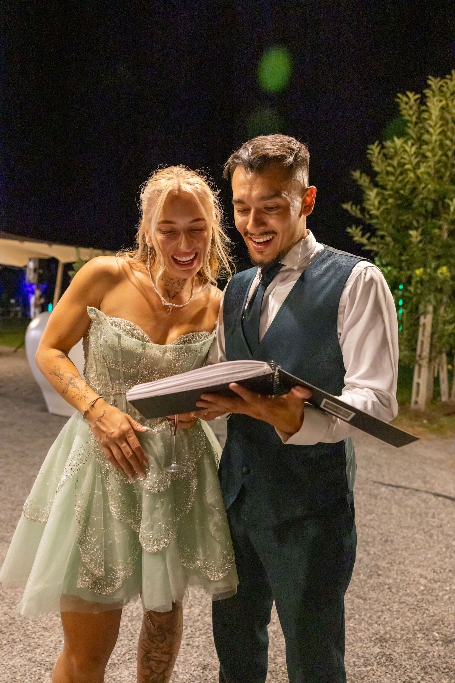 Les mariés qui contemplent l'album polaroid durant leur mariage en Suisse.