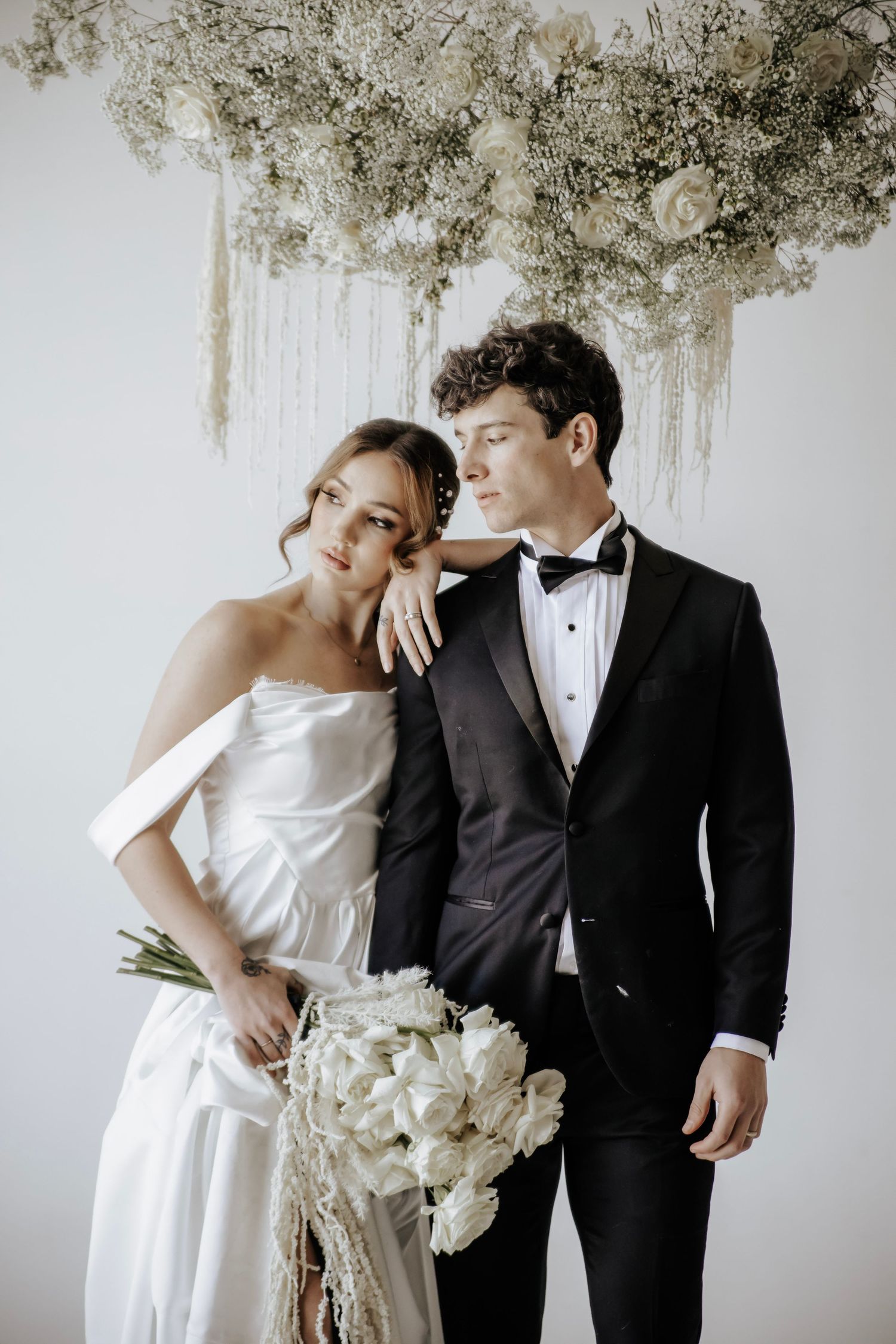 Bride and groom posing, bride is laying head on grooms shoulder
